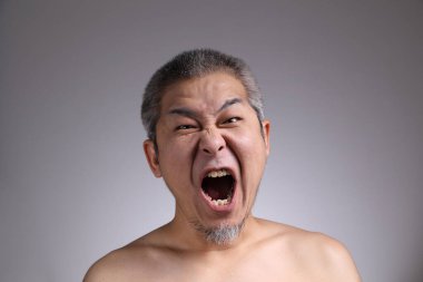 Gri arka planda Asyalı bir adamın portresi..