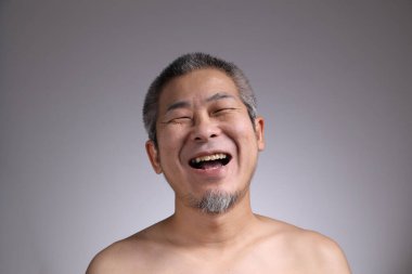 Gri arka planda Asyalı bir adamın portresi..