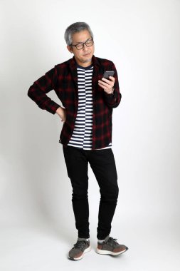 Beyaz arka planda duran Asyalı adam.