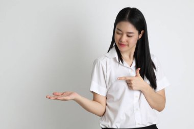 Üniversite üniformalı Asyalı kız beyaz arka planda duruyor..