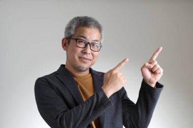 Beyaz arka planda duran akıllı Asyalı adam..