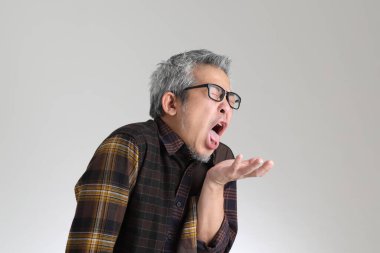 Beyaz arka planda duran kıdemli Asyalı adam.