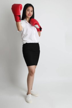 Üniversite üniformalı Asyalı kız beyaz arka planda duruyor..