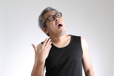 Beyaz arka planda duran spor üniformalı yaşlı Asyalı adam..