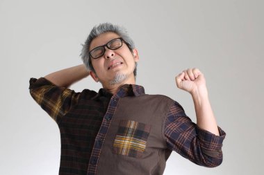 Beyaz arka planda duran kıdemli Asyalı adam.