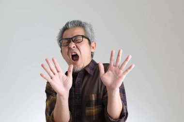 Beyaz arka planda duran kıdemli Asyalı adam.