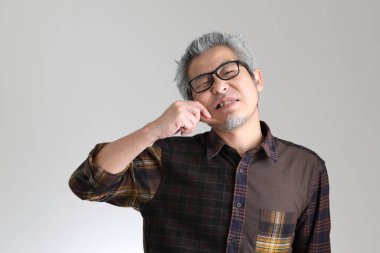 Beyaz arka planda duran kıdemli Asyalı adam.