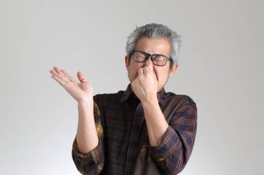 Beyaz arka planda duran kıdemli Asyalı adam.