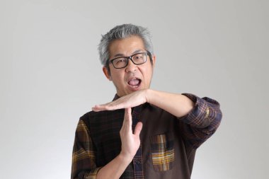 Beyaz arka planda duran kıdemli Asyalı adam.