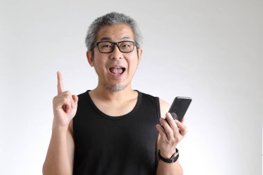 Beyaz arka planda duran spor üniformalı yaşlı Asyalı adam..