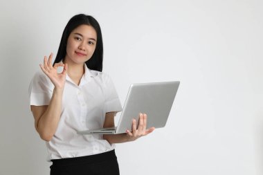 Üniversite üniformalı Asyalı kız beyaz arka planda duruyor..