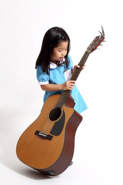 Whit arka planında akustik gitarı olan Asyalı genç kız..