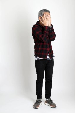 Beyaz arka planda duran Asyalı adam.