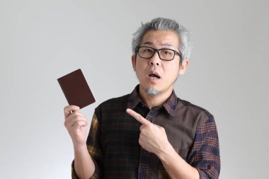 Beyaz arka planda duran kıdemli Asyalı adam.