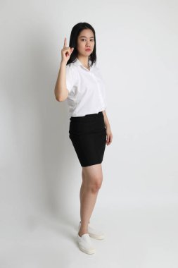 Üniversite üniformalı Asyalı kız beyaz arka planda duruyor..