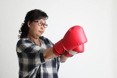 Beyaz arka planda duran yaşlı Asyalı kadın..