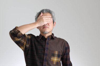 Beyaz arka planda duran kıdemli Asyalı adam.