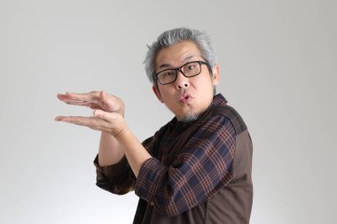 Beyaz arka planda duran kıdemli Asyalı adam.