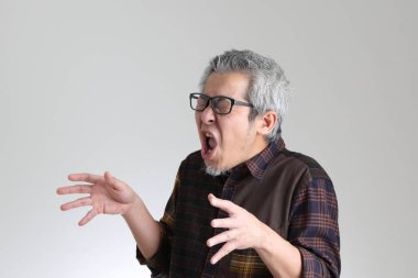 Beyaz arka planda duran kıdemli Asyalı adam.