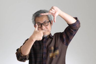 Beyaz arka planda duran kıdemli Asyalı adam.