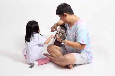 Asyalı adam kızına gitar çalmayı öğretiyor..