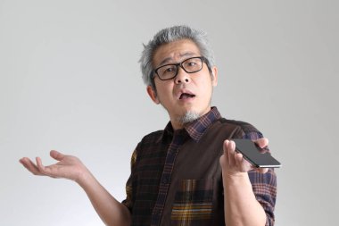 Beyaz arka planda duran kıdemli Asyalı adam.