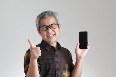 Beyaz arka planda duran kıdemli Asyalı adam.