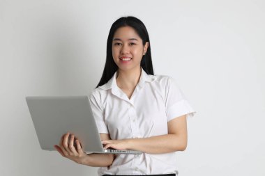 Üniversite üniformalı Asyalı kız beyaz arka planda duruyor..