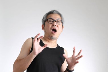 Beyaz arka planda duran spor üniformalı yaşlı Asyalı adam..