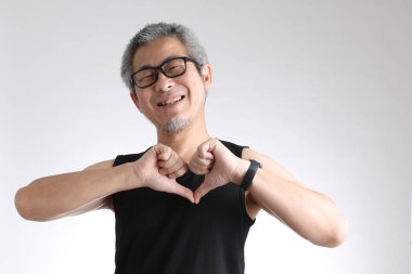 Beyaz arka planda duran spor üniformalı yaşlı Asyalı adam..