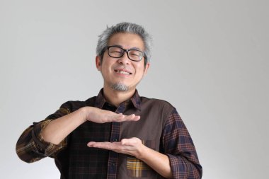 Beyaz arka planda duran kıdemli Asyalı adam.