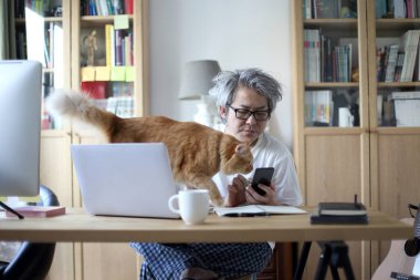 Ev stüdyosunda çalışan Asyalı adam..