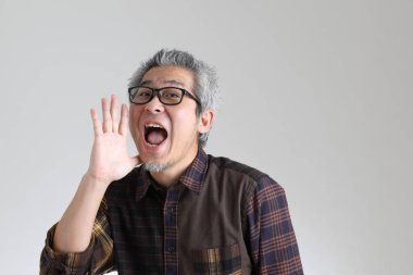 Beyaz arka planda duran kıdemli Asyalı adam.