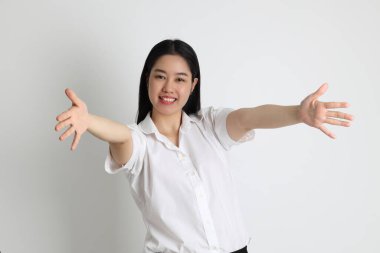 Üniversite üniformalı Asyalı kız beyaz arka planda duruyor..