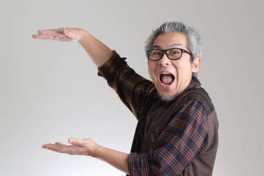 Beyaz arka planda duran kıdemli Asyalı adam.