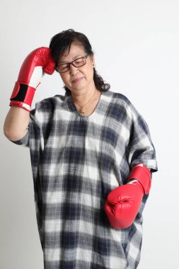 Beyaz arka planda duran yaşlı Asyalı kadın..