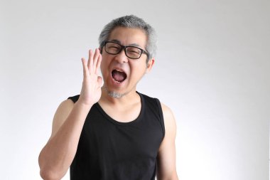 Beyaz arka planda duran spor üniformalı yaşlı Asyalı adam..