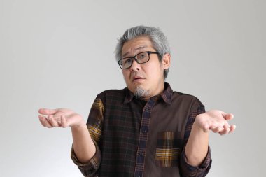 Beyaz arka planda duran kıdemli Asyalı adam.