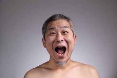 Gri arka planda Asyalı bir adamın portresi..