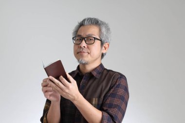 Beyaz arka planda duran kıdemli Asyalı adam.