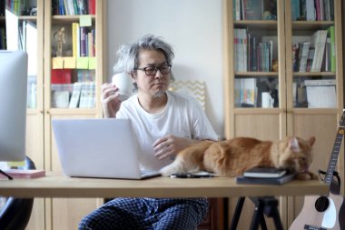 Ev stüdyosunda çalışan Asyalı adam..