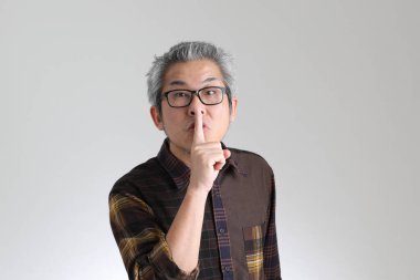 Beyaz arka planda duran kıdemli Asyalı adam.