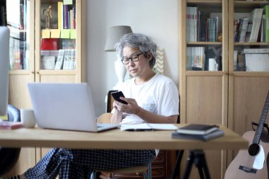 Ev stüdyosunda çalışan Asyalı adam..