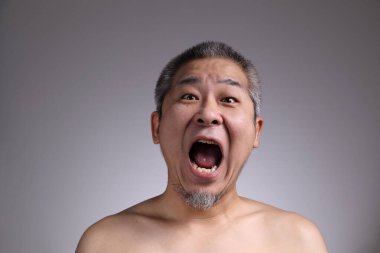 Gri arka planda Asyalı bir adamın portresi..