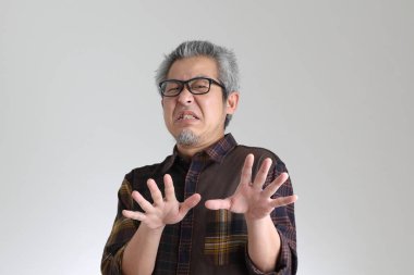 Beyaz arka planda duran kıdemli Asyalı adam.