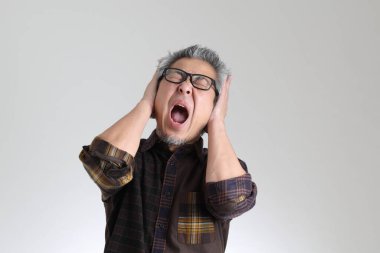 Beyaz arka planda duran kıdemli Asyalı adam.