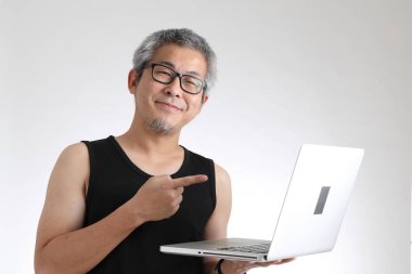 Beyaz arka planda duran spor üniformalı yaşlı Asyalı adam..