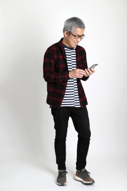 Beyaz arka planda duran Asyalı adam.