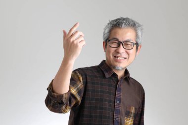 Beyaz arka planda duran kıdemli Asyalı adam.