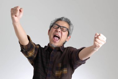 Beyaz arka planda duran kıdemli Asyalı adam.